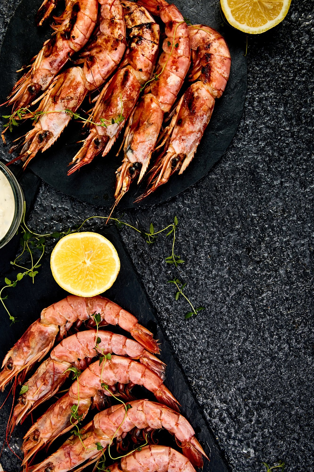 Grilled big tiger shrimps prawns on black slate plate